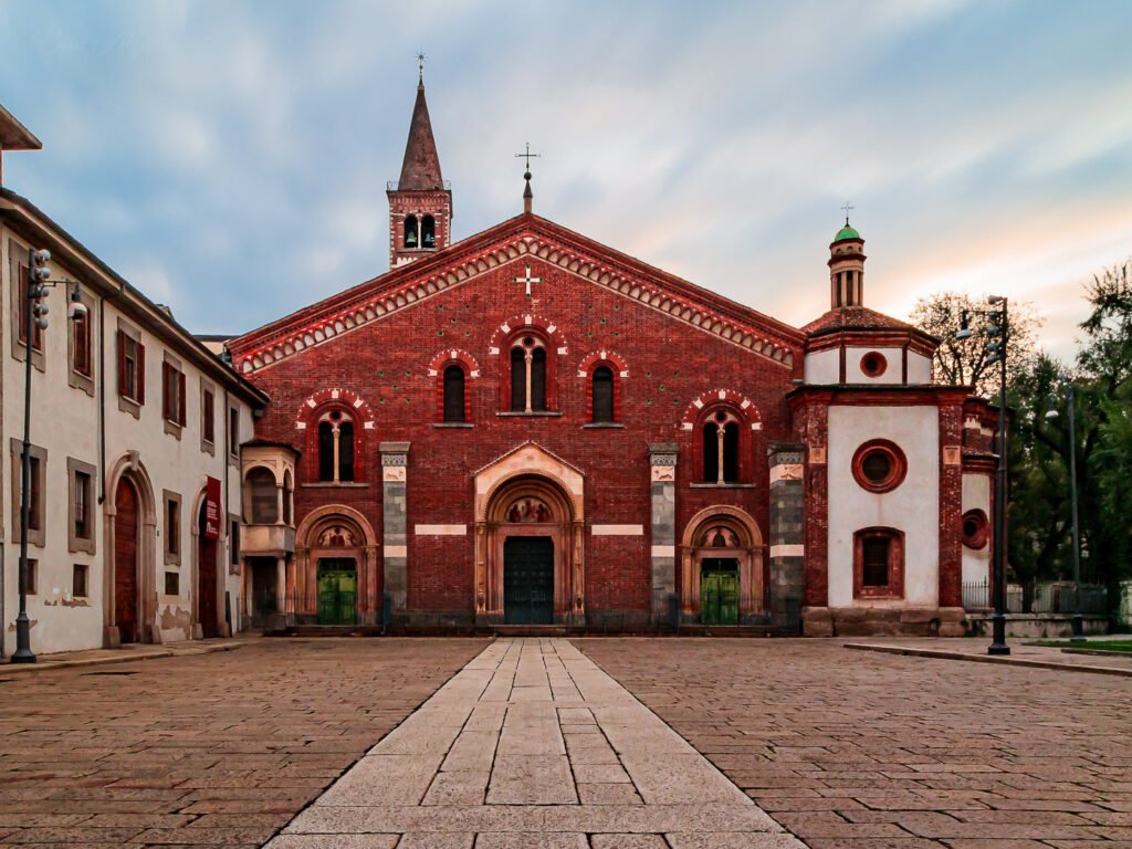 50-second sunrise exposure over Basilica di Sant’Eustorgio in Milan, with streaky clouds and warm early-morning light.