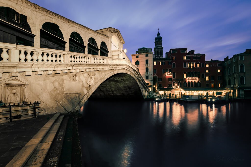 Long exposure of the Rialto Bridge in Venice, a 30-second capture at blue hour that blends the soft motion of the Grand Canal with glowing golden lights.